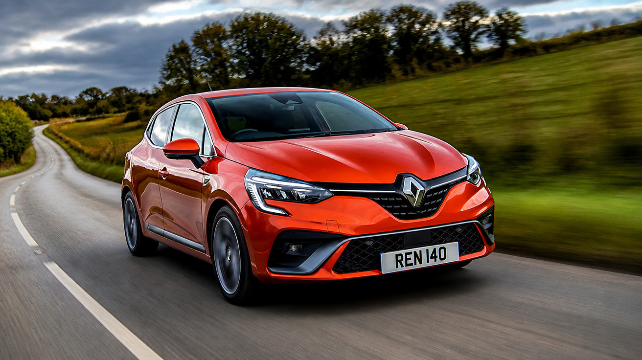 Renault Clio vermelho a circular numa estrada rural sob céu nublado e vegetação verde.